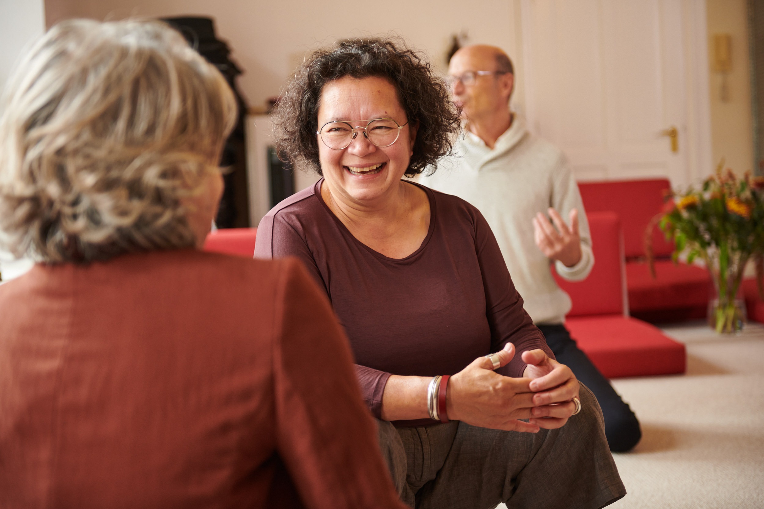 Twee vrouwen in een warm, lachend gesprek tijdens groepsoefeningen bij de School voor Zijnsoriëntatie